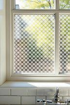 Geometric privacy window film with repeating decorative pattern